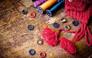 low light and close-up photograph of thread spools, tassels, and buttons